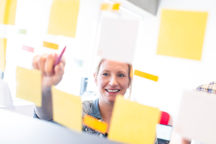 vrouw wijst naar post-it's